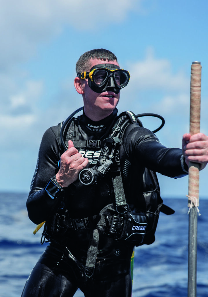 Scuba diver standing in water wearing a Cressi jacket BCD
