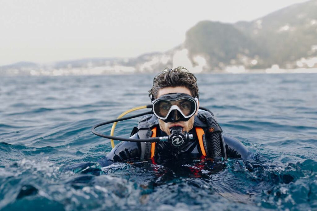 Diver breathing through a regulator at the sea surface