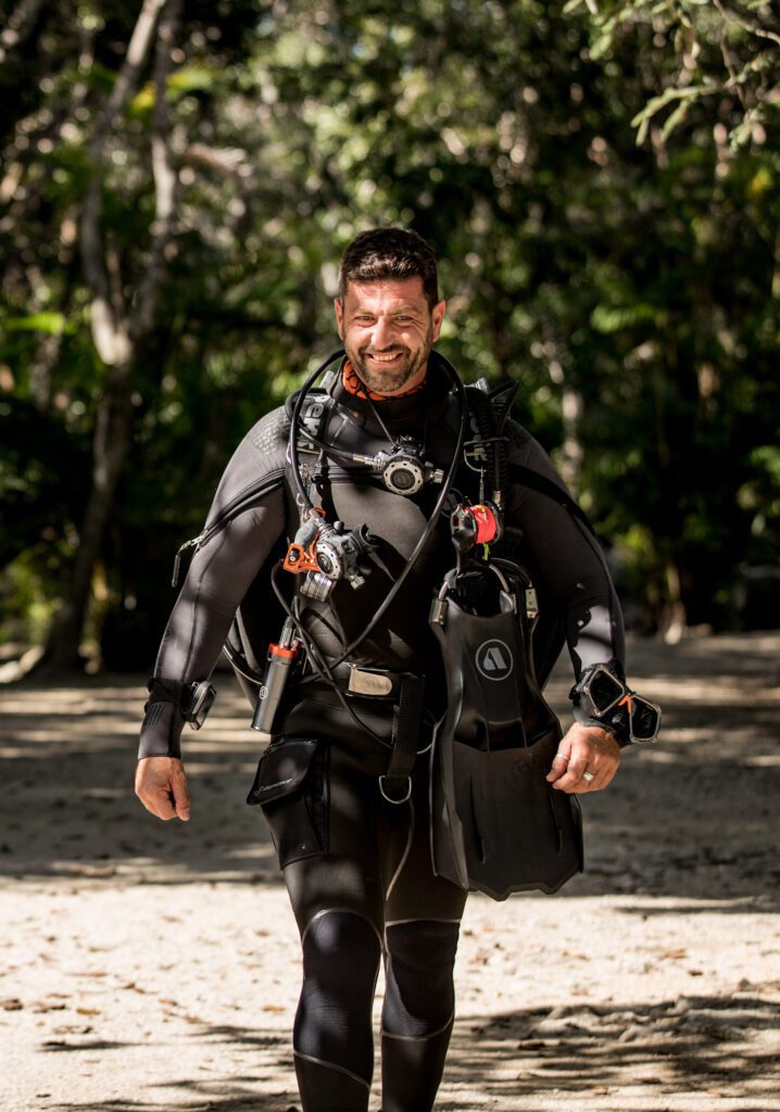 Diver walking to the water wearing an Apeks EXOTEC BCD