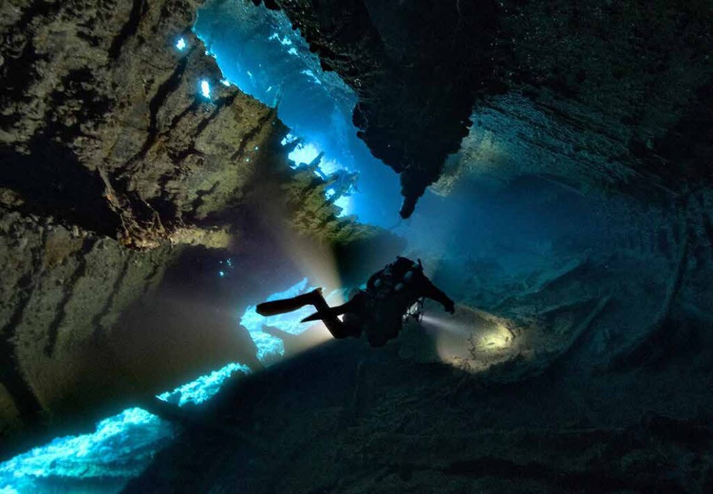 Technical diver illuminating an underwater cave