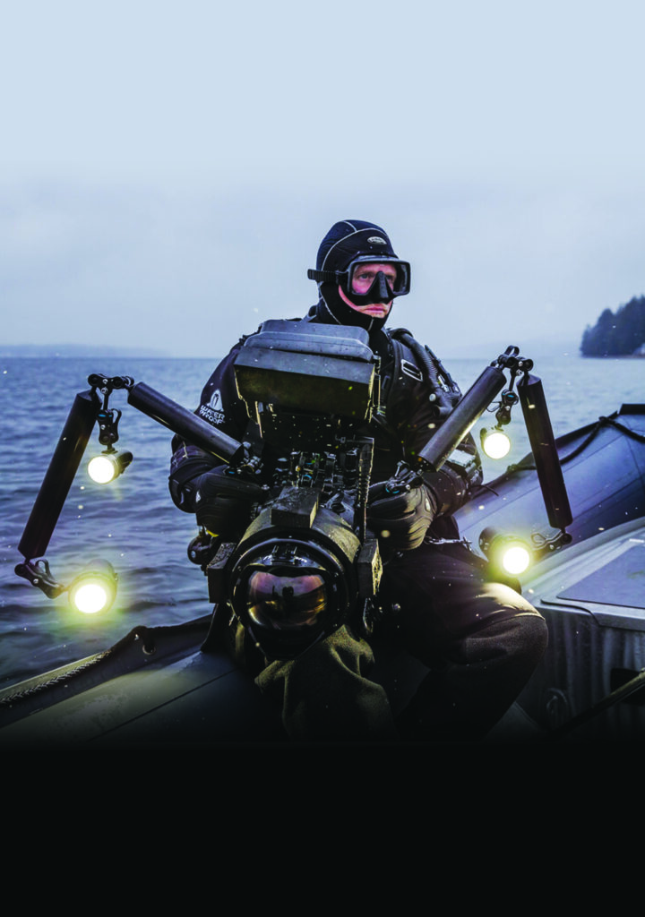 Underwater photographer on a dive boat with an illuminated camera rig