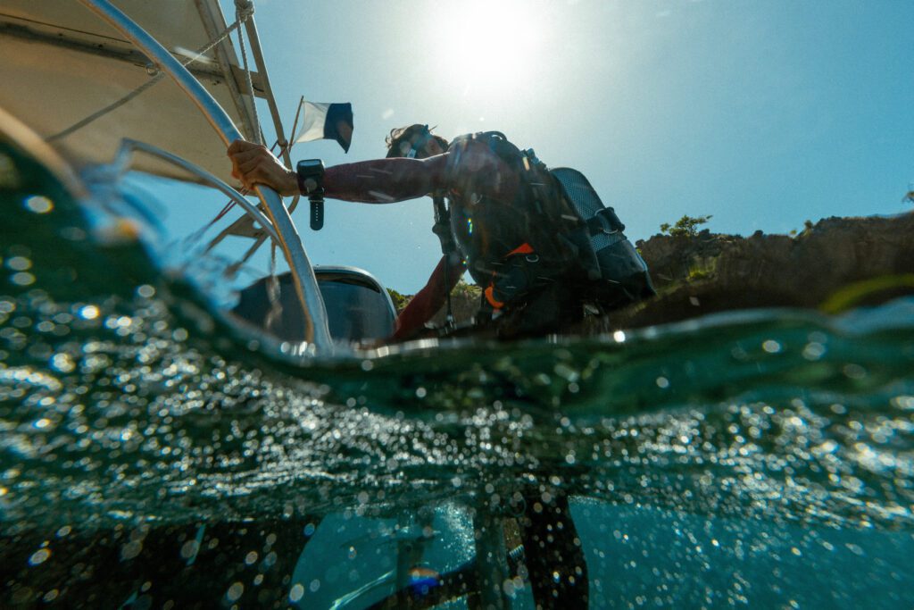 Aqualung-equipped scuba diver boarding a dive boat
