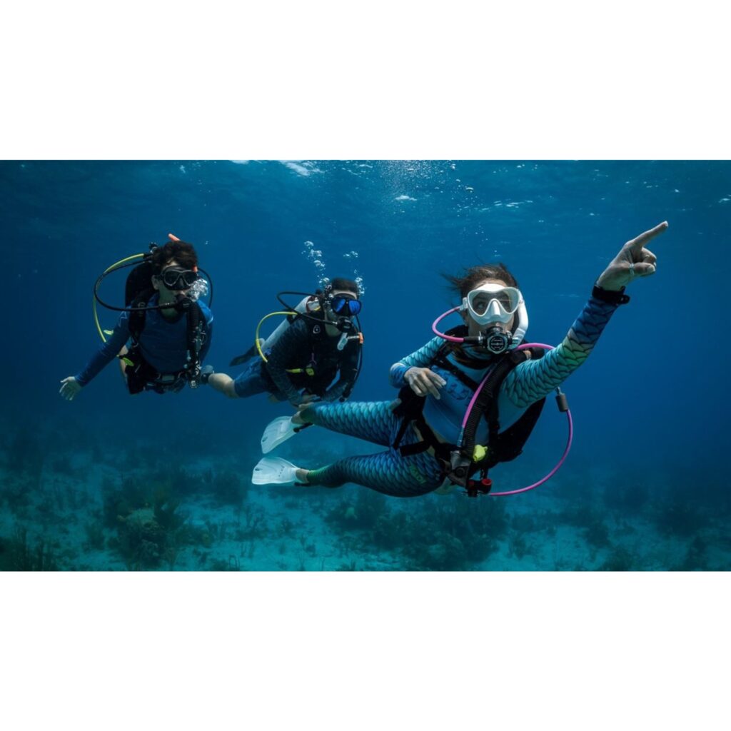 Three scuba divers swimming underwater