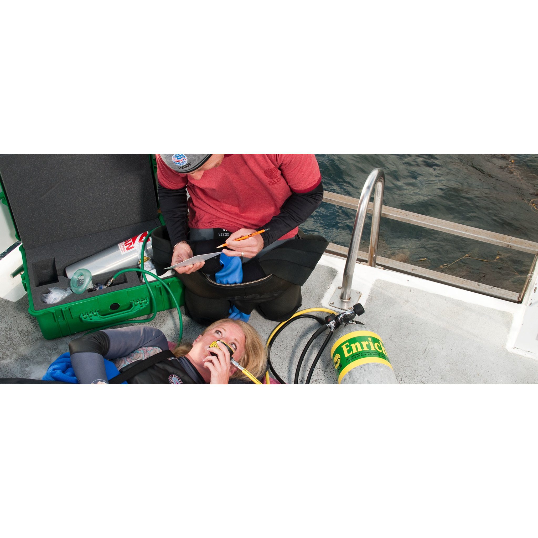 Student assisting a person using an emergency oxygen mask — official PADI Emergency Oxygen Provider course photograph